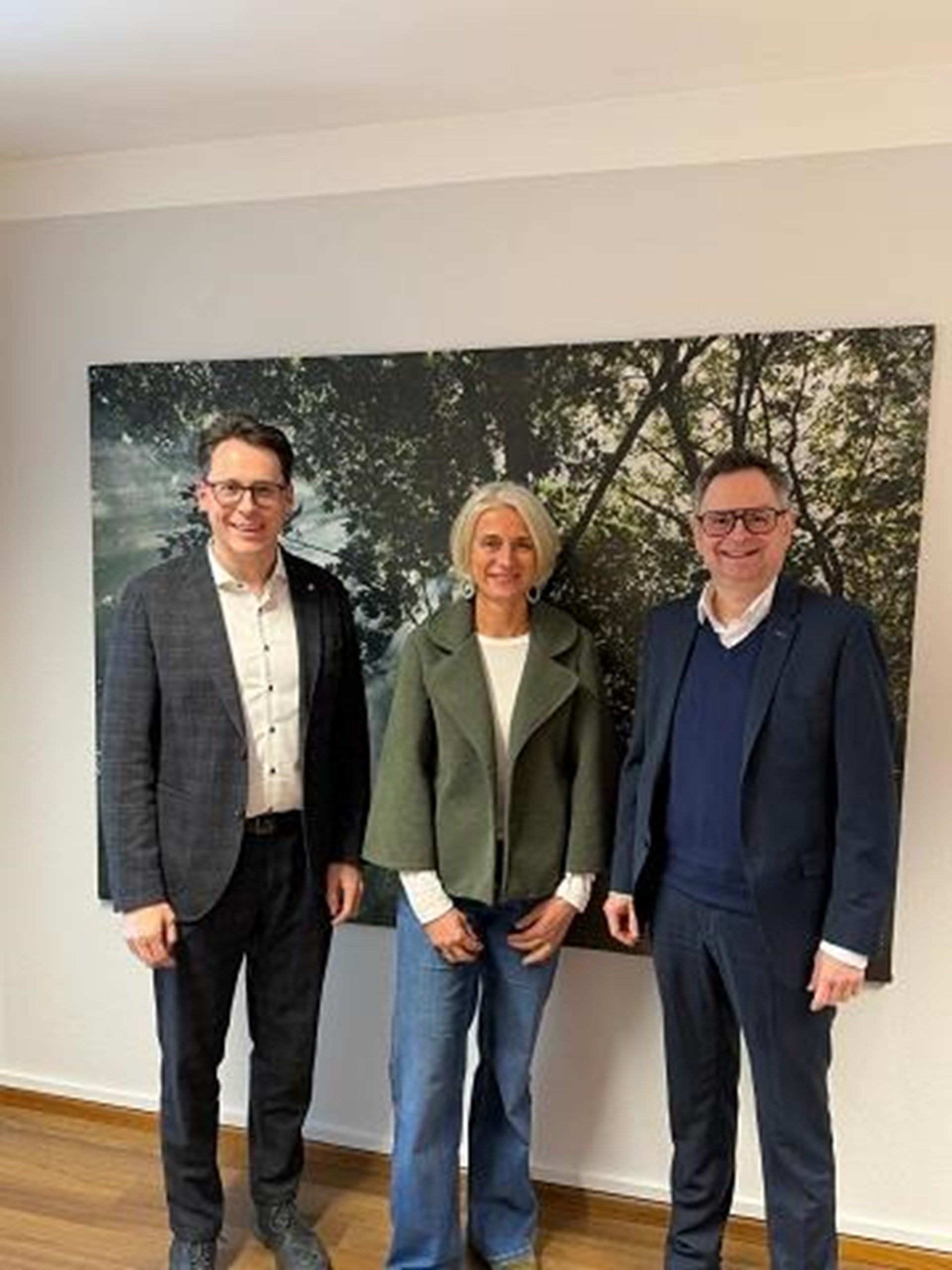 Vorsitzender OB Christian Moser und sein Stellvertreter Stefan Swihota gemeinsam mit Vorständin Manuela Stephan stehen vor einem Wandbild.