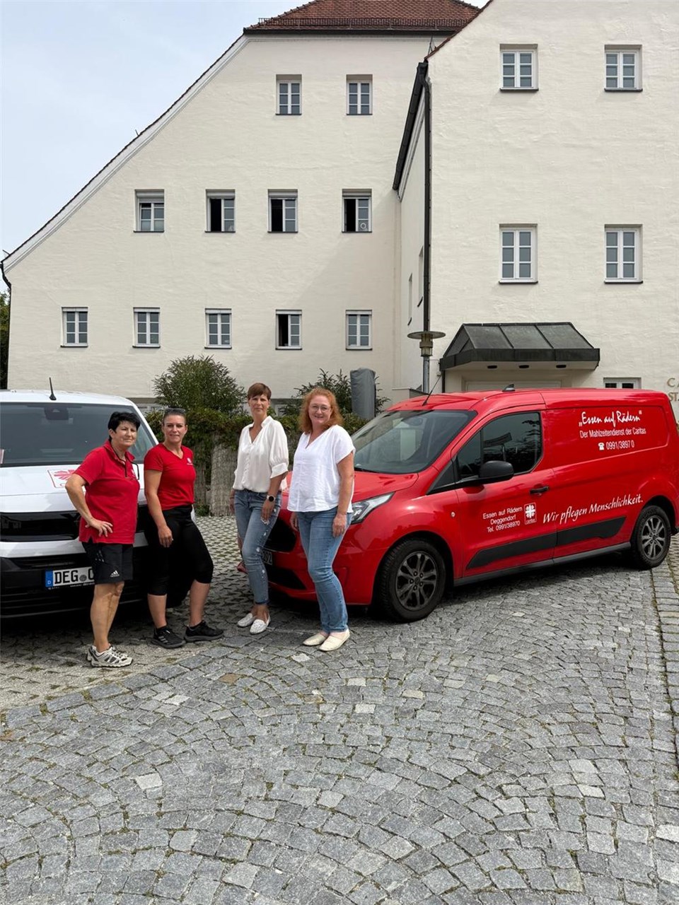 Team Essen auf Rädern vor den Autos